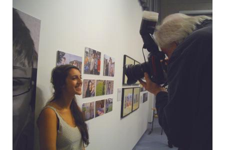 A young photographer poses with her exhibited work
